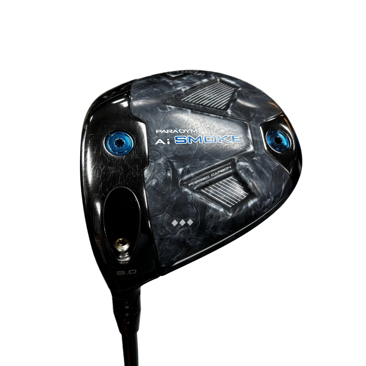 A close-up of a Paradyne A1 Smoke golf club head on a stand, featuring a textured black and gray pattern with blue accents and visible Cleveland brand logos in the blurred background.