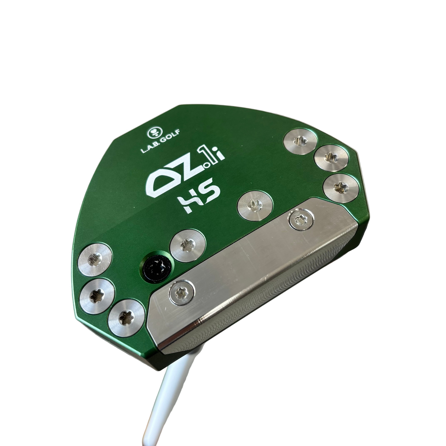 Close-up of a golf putter head with 'OZ' branding on a concrete floor.