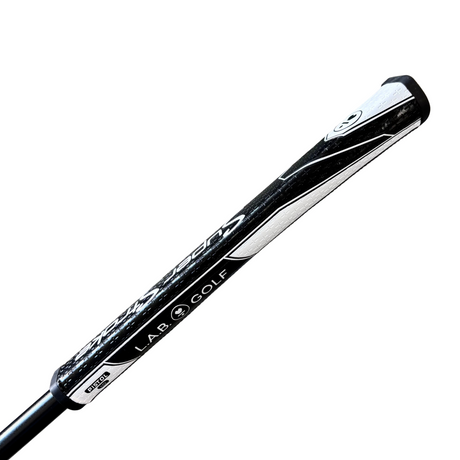 Golf club shaft with 'LAB. GOLF' branding on a concrete surface.