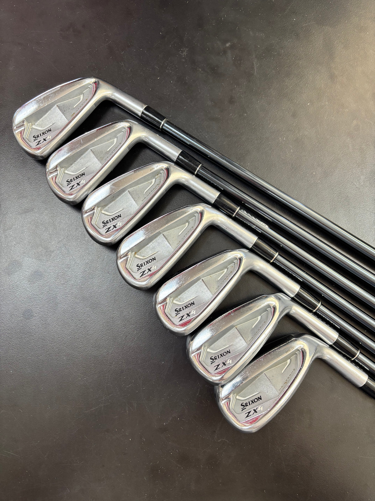 Set of golf clubs on a dark surface