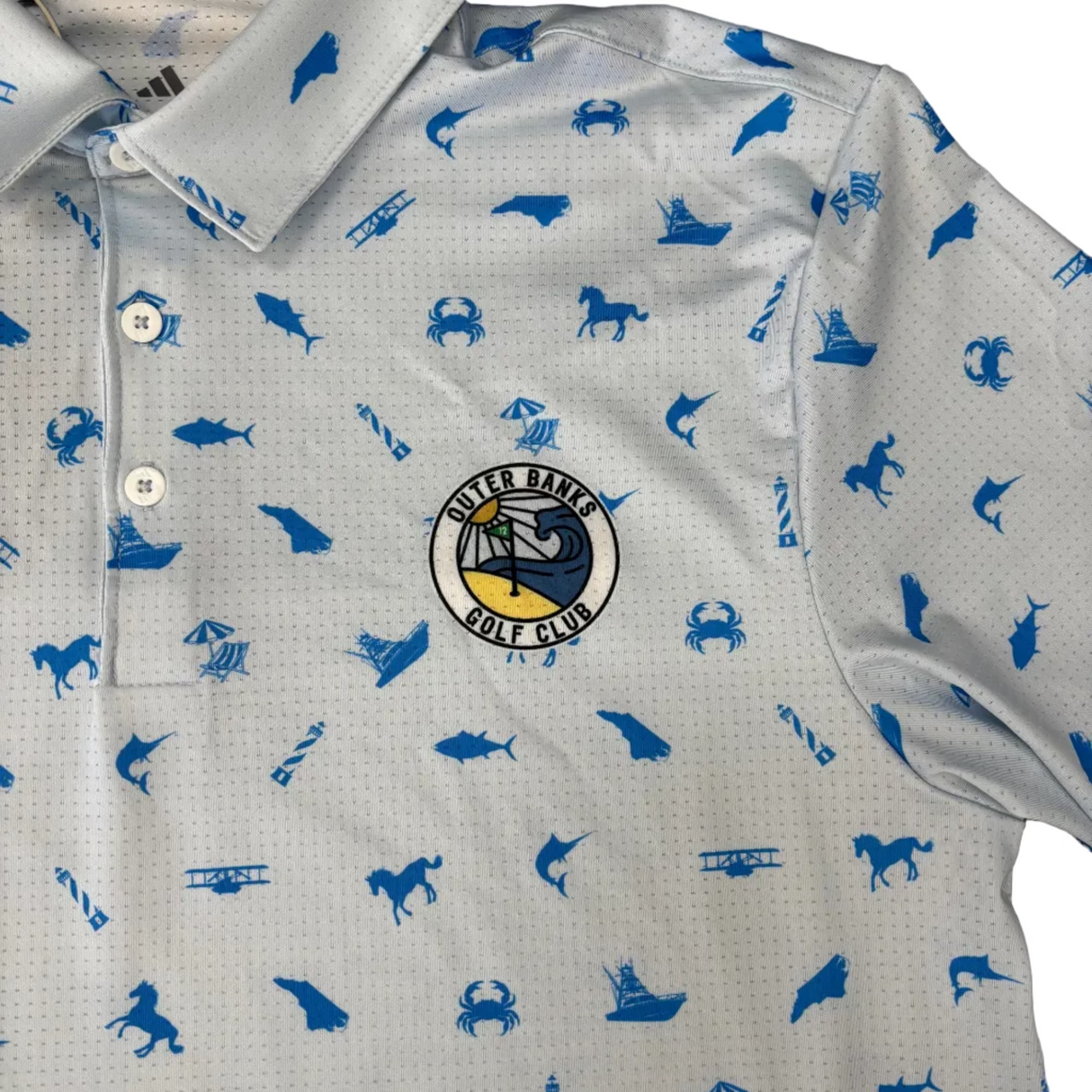 Gray shirt with blue animal prints and a logo on a brown surface