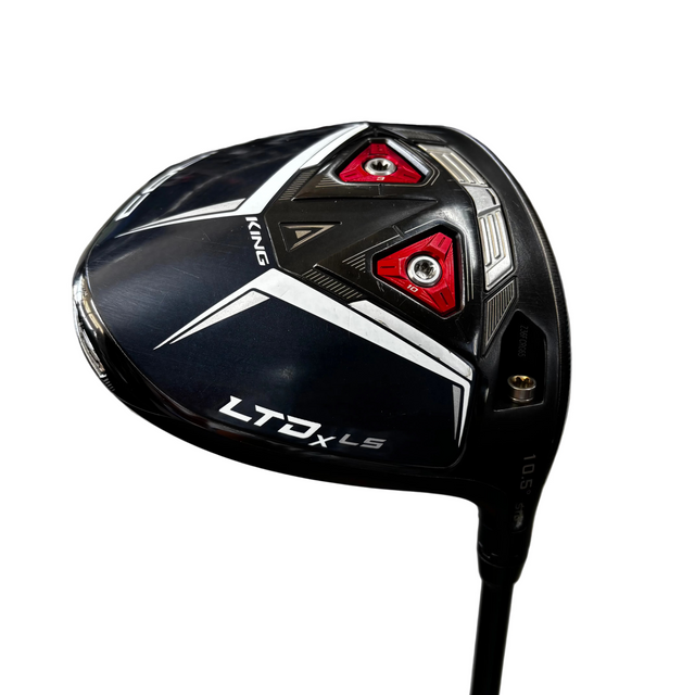 A close-up of a black and white Callaway LTD-X LS golf driver head with red accents, resting on a golf stand in a shop setting.