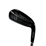 A close-up of a Cleveland Smart Sole golf iron club head, showing the brand name and model text on the black metal clubface, photographed against a gray concrete floor.
