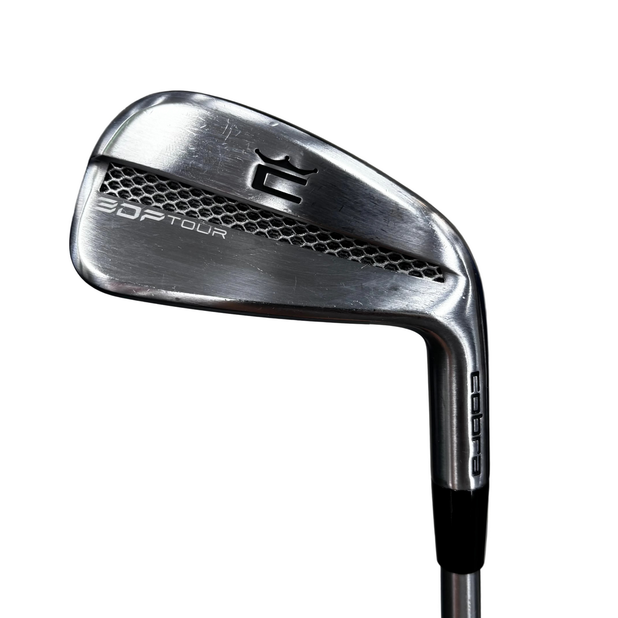 A close-up shot of a Cobra  3DP Tour golf iron, showing the club head and part of the shaft against a blurred gray concrete floor background.