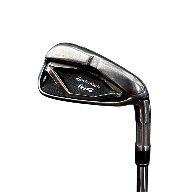 TaylorMade M6 iron golf club head shown close-up on a gray concrete floor, with part of a blue golf ball marker visible on the right.