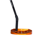 Orange golf club head with black shaft on a concrete floor