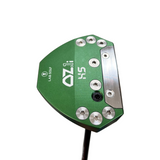 Close-up of a golf putter head with 'Lab Golf' branding on a concrete floor.