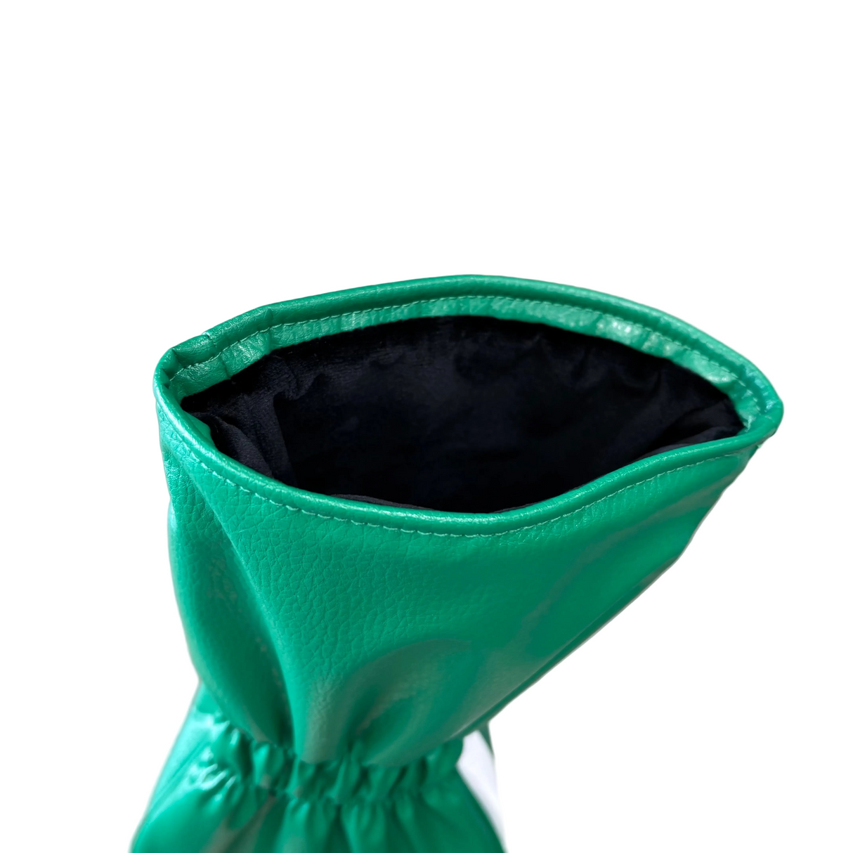 Green leather glove with black lining on a metallic surface