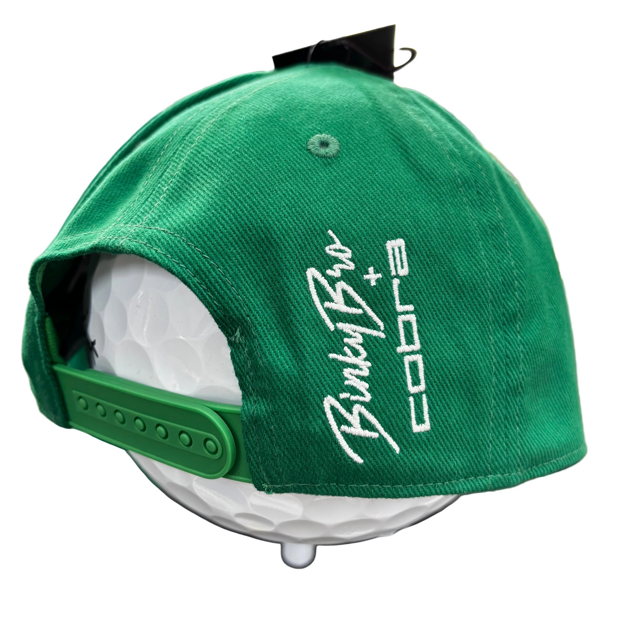 Green cap with white text on a mannequin head, blurred background
