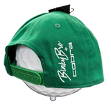 Green cap with white text on a mannequin head, blurred background