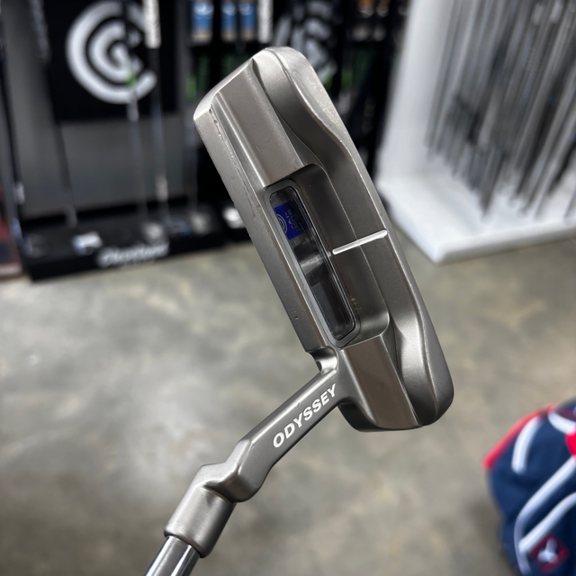 Close-up of a Odyssey golf putter with a blurred store background