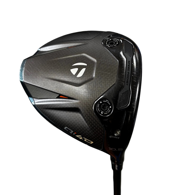 Golf club head with TaylorMade logo on a store floor.