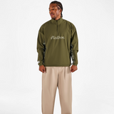 Person wearing a green jacket with 'Fusalba' branding and beige pants on a white background