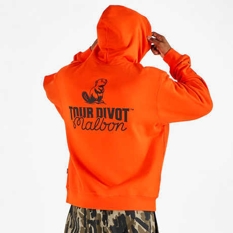 Person wearing an orange hoodie with 'Tour Divot Malbon' branding on the back, standing against a white background.